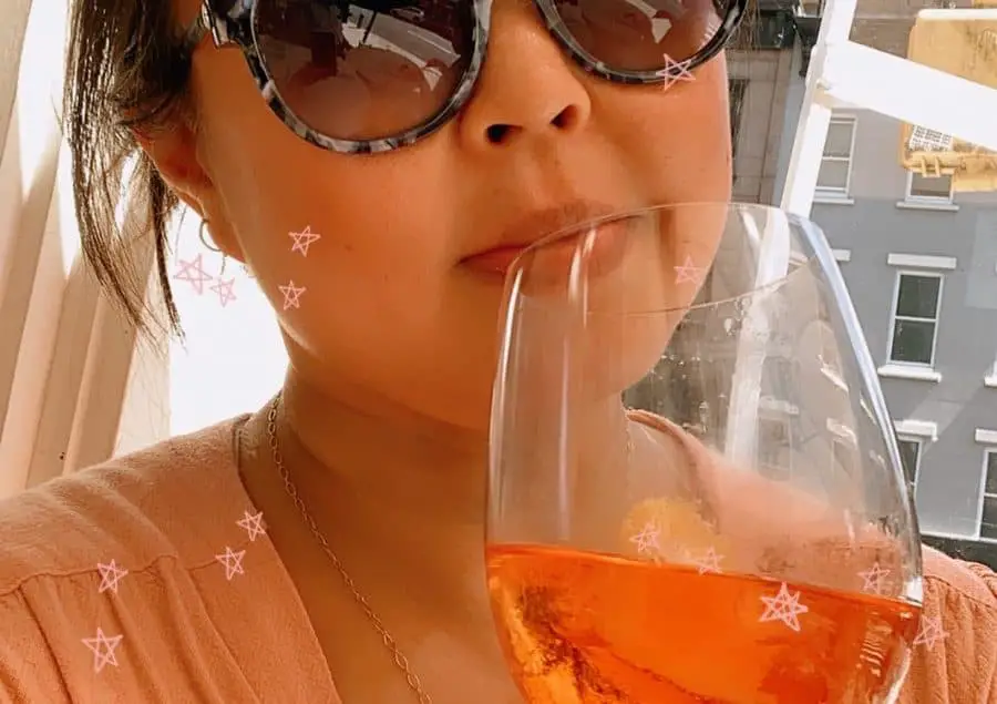 Girl in sunglasses holding an aperol spritz