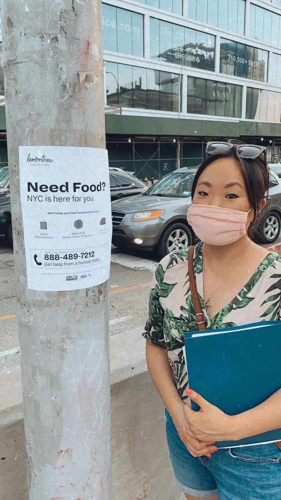 asian girl with pink mask standing by a post with a flyer